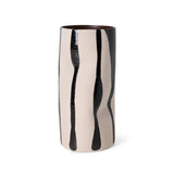 A tall cylindrical ceramic vase with a glossy finish, featuring a beige and black abstract dripping pattern, set against a plain white background.