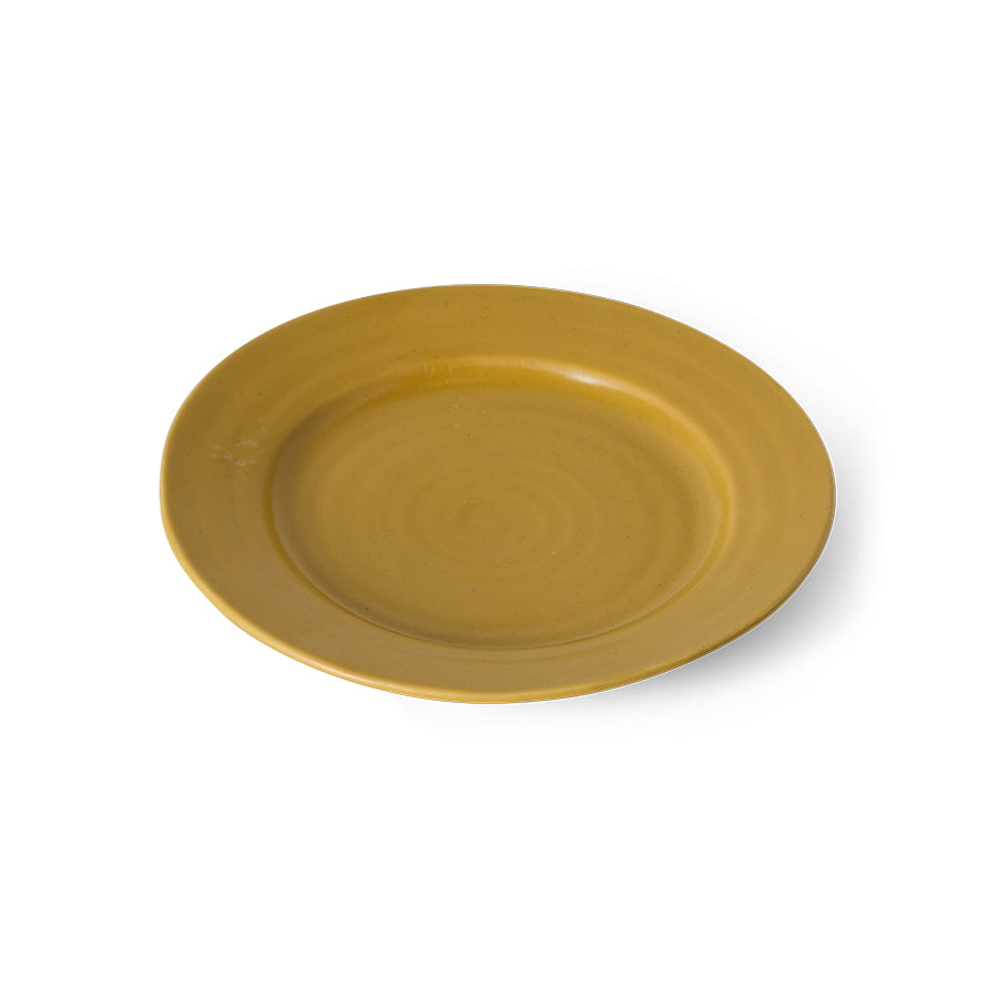A round ceramic plate in a warm mustard yellow color, shown from a top-down perspective on a clean white background.