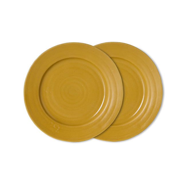 Two round yellow ceramic plates with concentric ring patterns, overlapping on a solid white background.