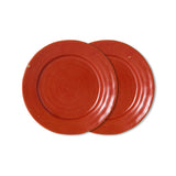 Two round ceramic plates in a warm terracotta red color, overlapping on a plain white background.