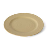 A round ceramic plate in a light beige color with subtle concentric ring textures, shown from a high-angle perspective on a white background.