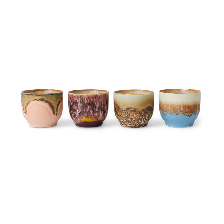 Set of four ceramic cups with gradient glaze on a white background