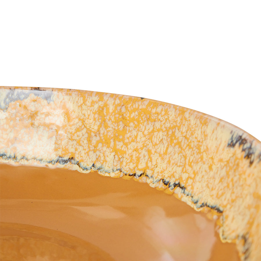 Close-up of a ceramic plate with a textured edge on a white background