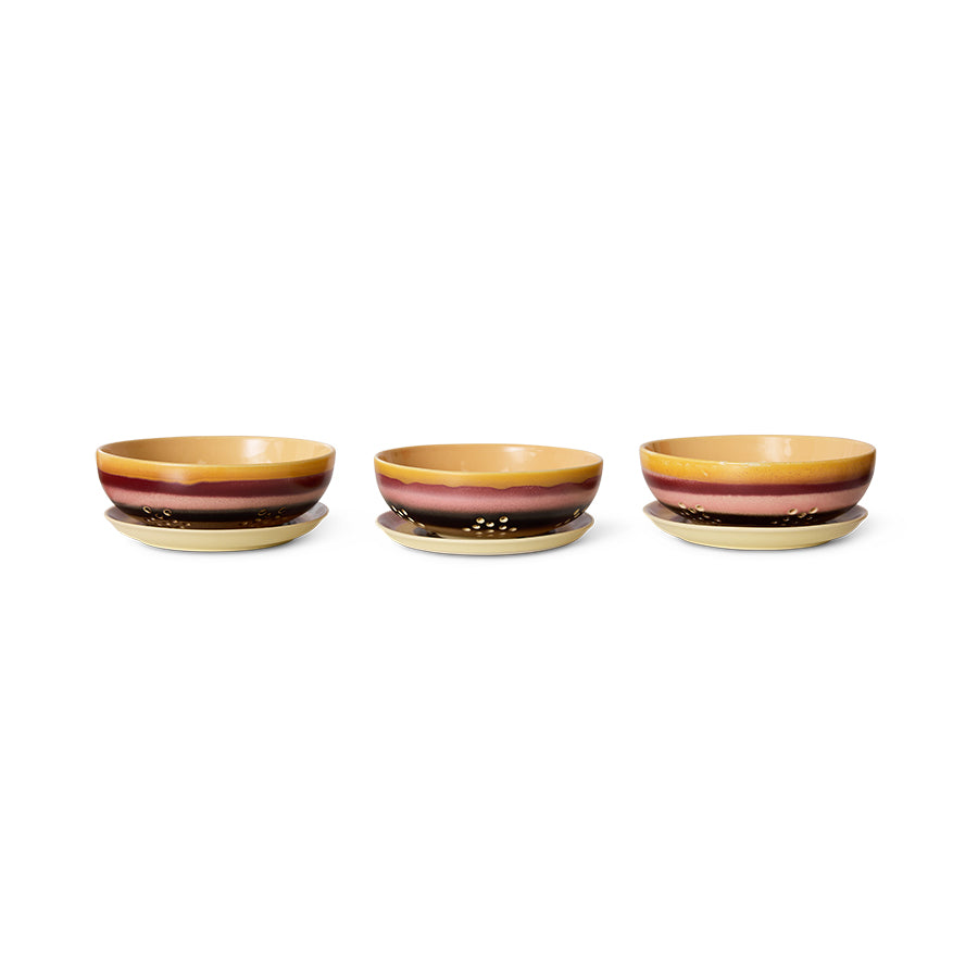 Three ceramic bowls with a striped design on a white background