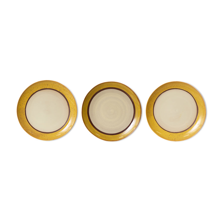 Three round plates with gold rims on a white background