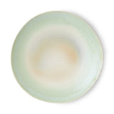 Round ceramic plate with a gradient color from green to beige on a white background