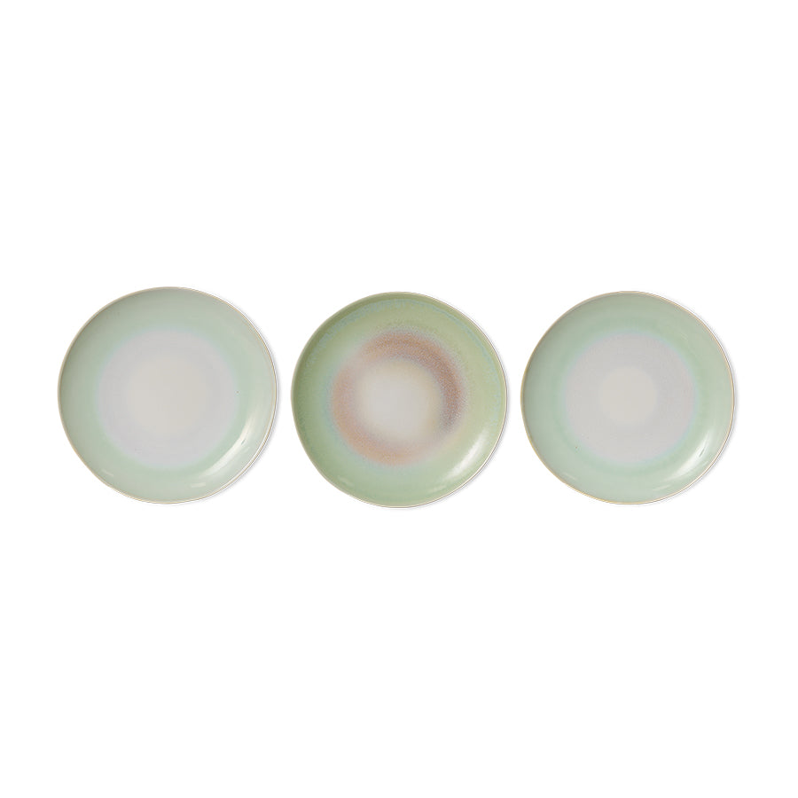 Three round ceramic plates with a subtle gradient of green and white on a white background
