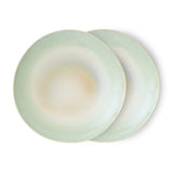 Two light green ceramic plates on a white background