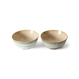 Two ceramic bowls with a beige interior and green exterior on a white background