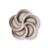 Ceramic flower-shaped dish with pink rim on a white background