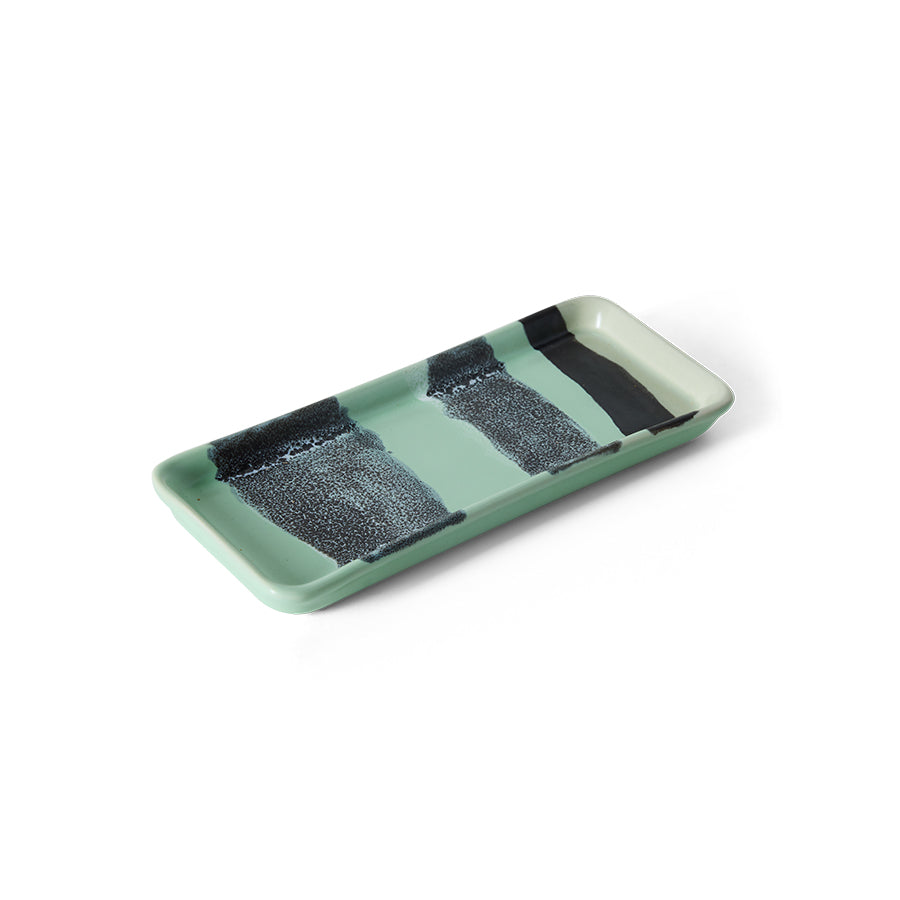 Green rectangular ceramic tray with black textured sections on a white background