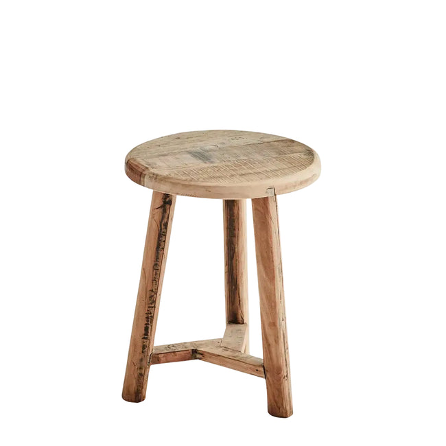 A rustic round wooden stool with a natural light brown finish and visible grain, set against a plain light gray background.