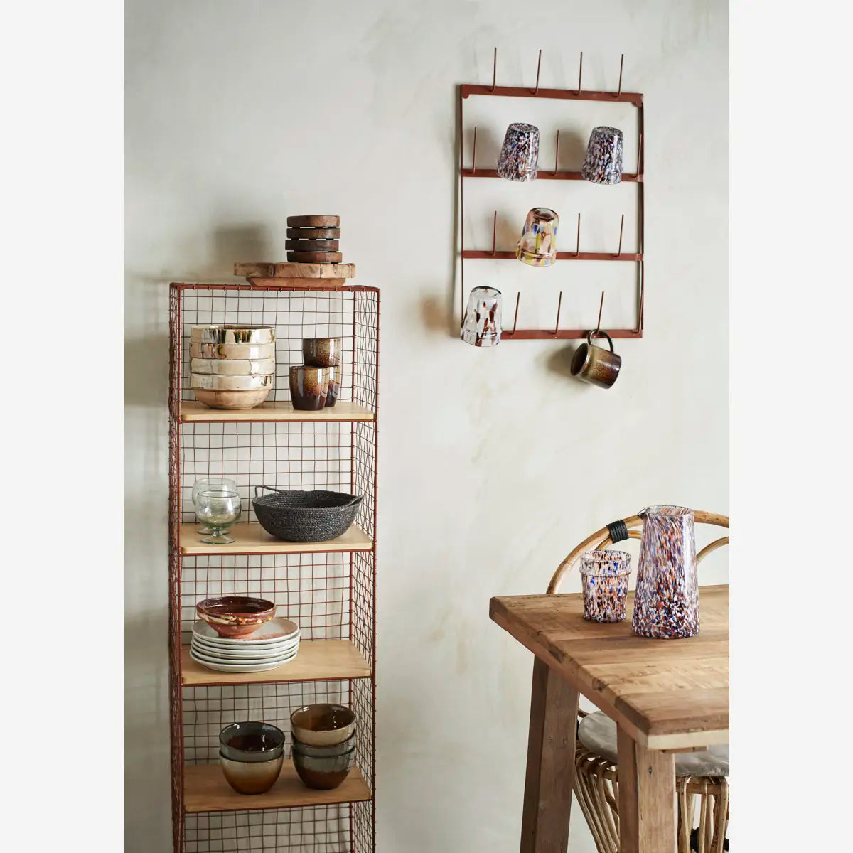 Wooden shelves with ceramic items against a light wall, next to a wooden table.