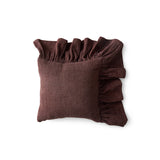 Brown pillow with ruffled edges on a white background